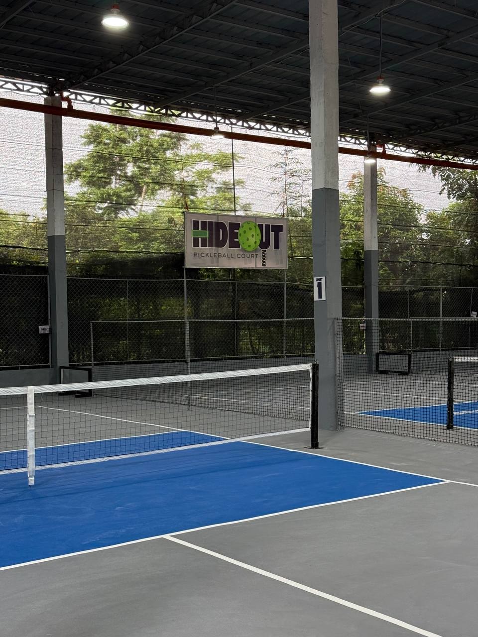 Court 1 at HIDEOUT with the club sign on the fence